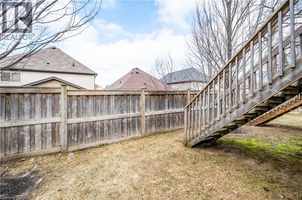 Grassed outdoor area with a wood privacy fence and a wood staircase - 224 Jessica Crescent Unit# B, Kitchener, ON