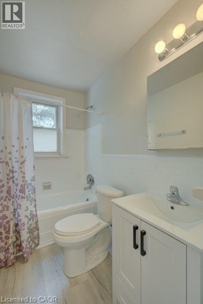 White vanity with black cabinet pulls, integrated sink, chrome faucet, and overhead light bar - 141 Chapel Street, Kitchener, ON