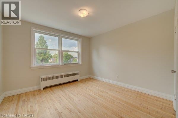 Light wood-finish flooring, white trim, and neutral wall tones - 141 Chapel Street, Kitchener, ON