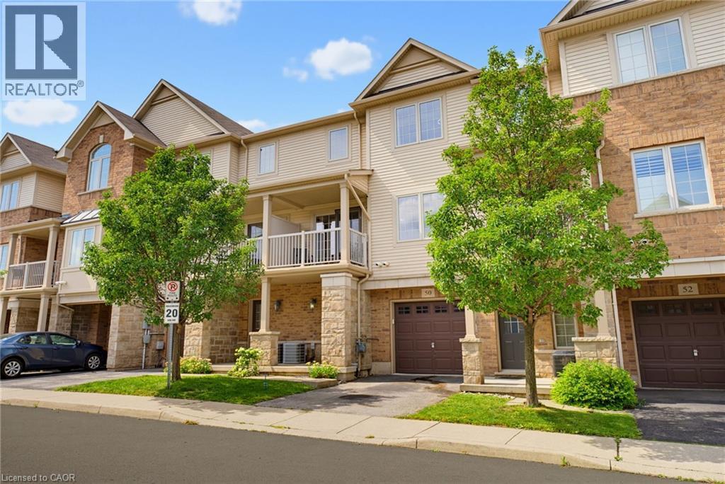 Three-story townhome with brick and siding facade, private garage, and an upper-level balcony - 541 Winston Road Unit# 50, Grimsby, ON