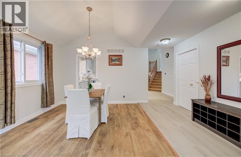 Dining area featuring vaulted ceilings, a multi-light chandelier, and wood-finish flooring - 245 Fern Crescent, Waterloo, ON