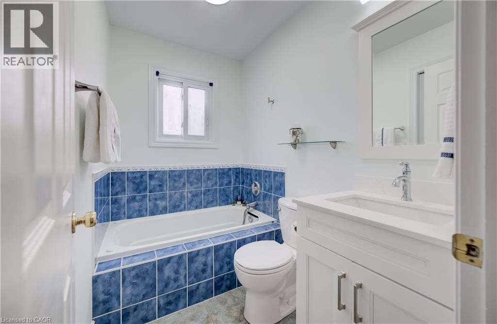 White vanity with integrated sink, chrome faucet, and framed mirror - 245 Fern Crescent, Waterloo, ON