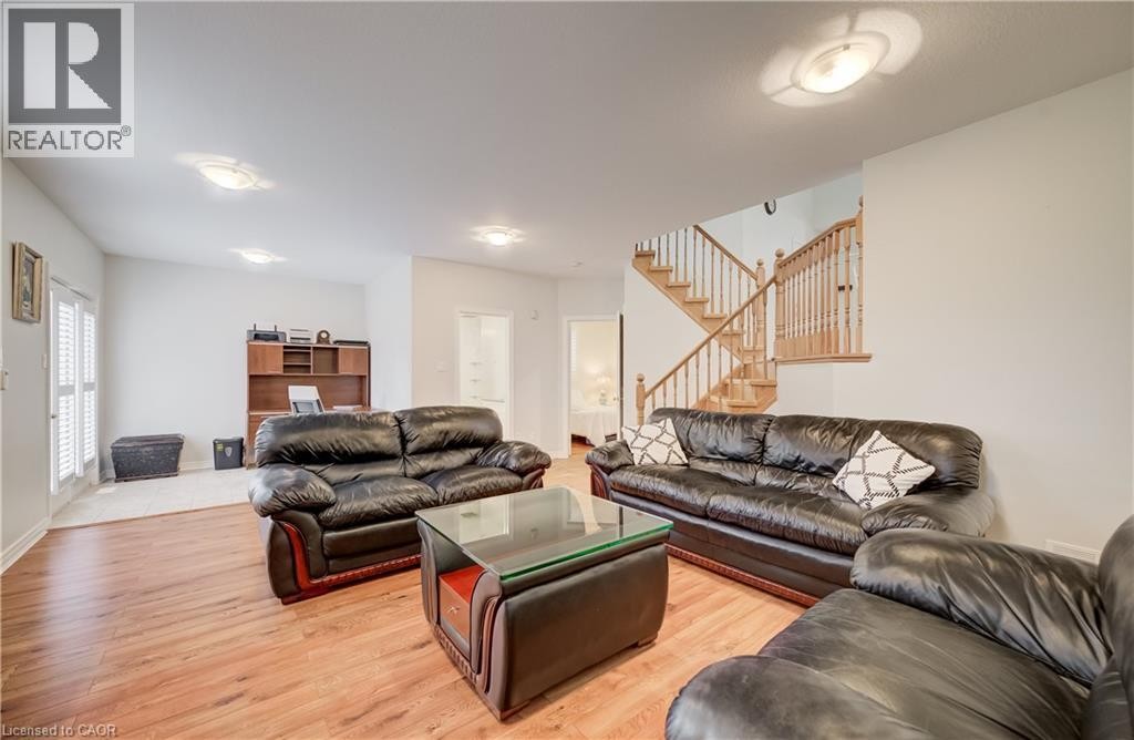 Wood-finish flooring throughout, integrated ceiling lighting, built-in shelving, and a wood staircase with balusters - 245 Fern Crescent, Waterloo, ON