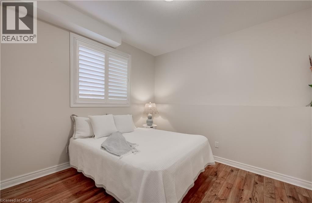 Wood-finish flooring with white baseboards, white window shutters, and neutral wall paint - 245 Fern Crescent, Waterloo, ON