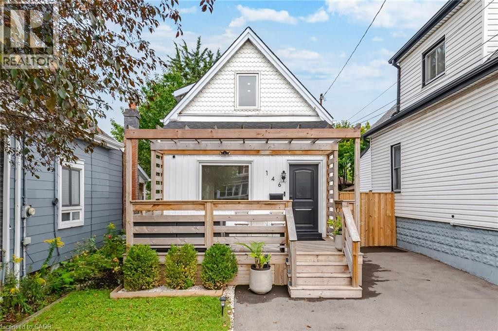 White siding exterior with a front wood deck, wood pergola, and wood steps - 146 Campbell Avenue, Hamilton, ON