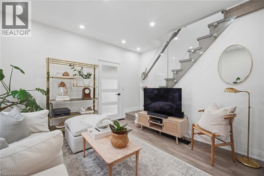 Recessed ceiling lighting, wood-finish flooring, staircase with glass railing and wood treads, white interior door with frosted panels - 146 Campbell Avenue, Hamilton, ON