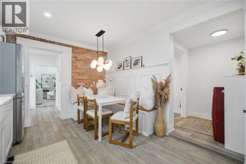 Brick accent wall, wood-finish flooring, recessed lighting, built-in bench seating, contemporary pendant lighting - 146 Campbell Avenue, Hamilton, ON 