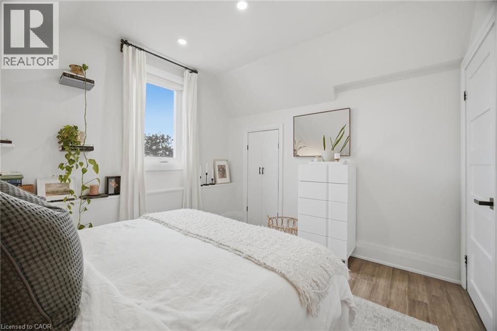 White walls with a window, wood-finish flooring, and a flush-mounted ceiling light - 146 Campbell Avenue, Hamilton, ON