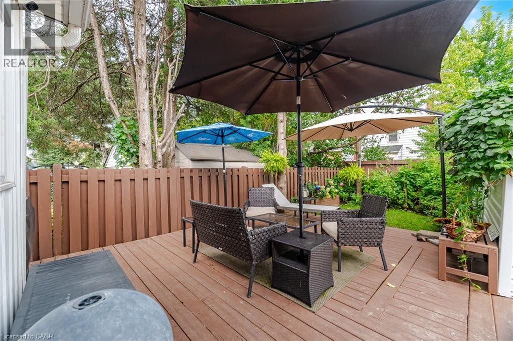 Wood-finish deck with a brown privacy fence and landscaped perimeter - 146 Campbell Avenue, Hamilton, ON