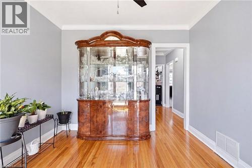 Hardwood flooring extending throughout, complemented by crown molding and light gray wall tones - 127 Taylor Avenue, Hamilton, ON 