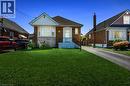 Brick exterior featuring a gabled roofline, bay window, and covered entry - 127 Taylor Avenue, Hamilton, ON 
