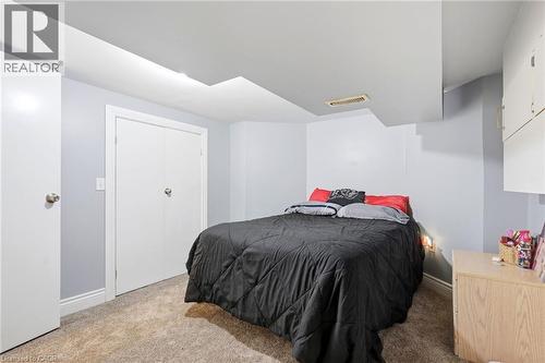Carpeted room with light gray walls, white trim, and a white bi-fold closet - 127 Taylor Avenue, Hamilton, ON 