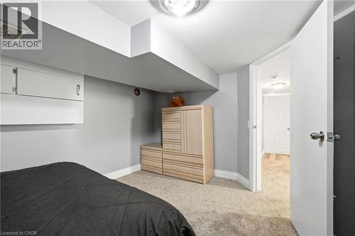 Finished room featuring recessed ceiling beams, light gray painted walls, and neutral carpet flooring - 127 Taylor Avenue, Hamilton, ON 