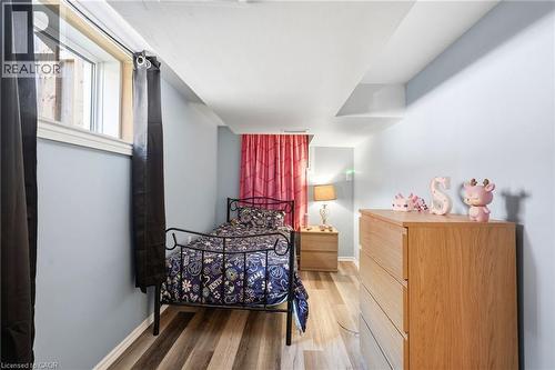 Room featuring wood-finish flooring, light blue walls, and a recessed window with white trim - 127 Taylor Avenue, Hamilton, ON 