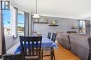 Dining area featuring wood-finish flooring, a pendant light fixture, and large windows - 127 Taylor Avenue, Hamilton, ON 