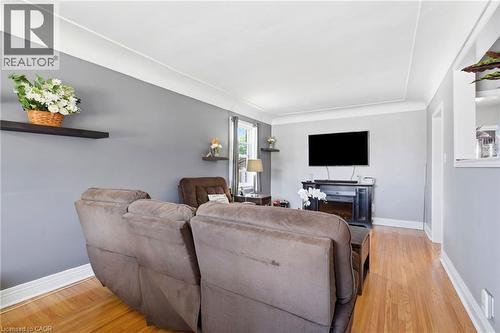 Light-filled room featuring wood-finish flooring, light gray walls, a white ceiling, and white baseboards - 127 Taylor Avenue, Hamilton, ON 