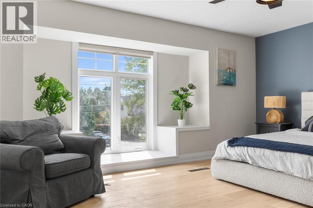 Light wood-finish flooring with a multi-pane window featuring a window seat and built-in storage - 293 North Shore Boulevard E, Burlington, ON