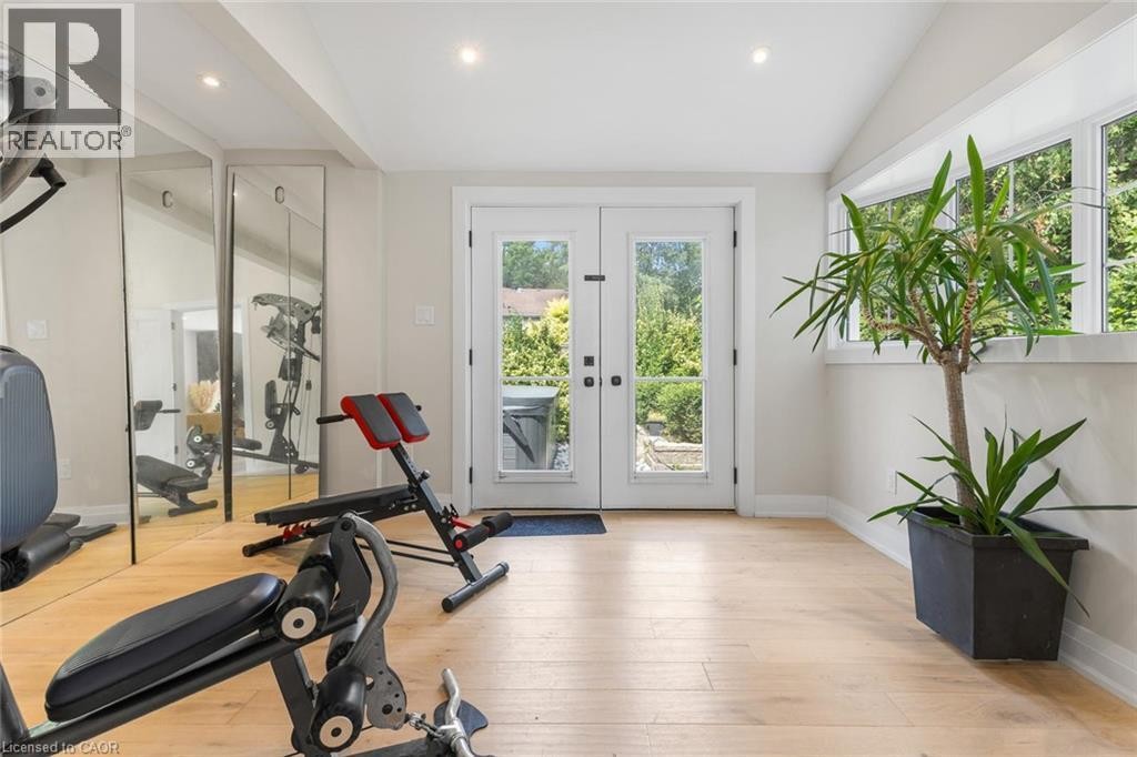Hardwood-style flooring, mirrored wall, recessed lighting, white French doors, and transom windows - 293 North Shore Boulevard E, Burlington, ON