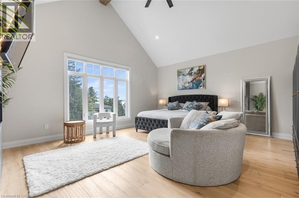 Vaulted ceiling with exposed wood beam, large multi-pane window, light wood-finish flooring, and light-toned wall paint - 293 North Shore Boulevard E, Burlington, ON