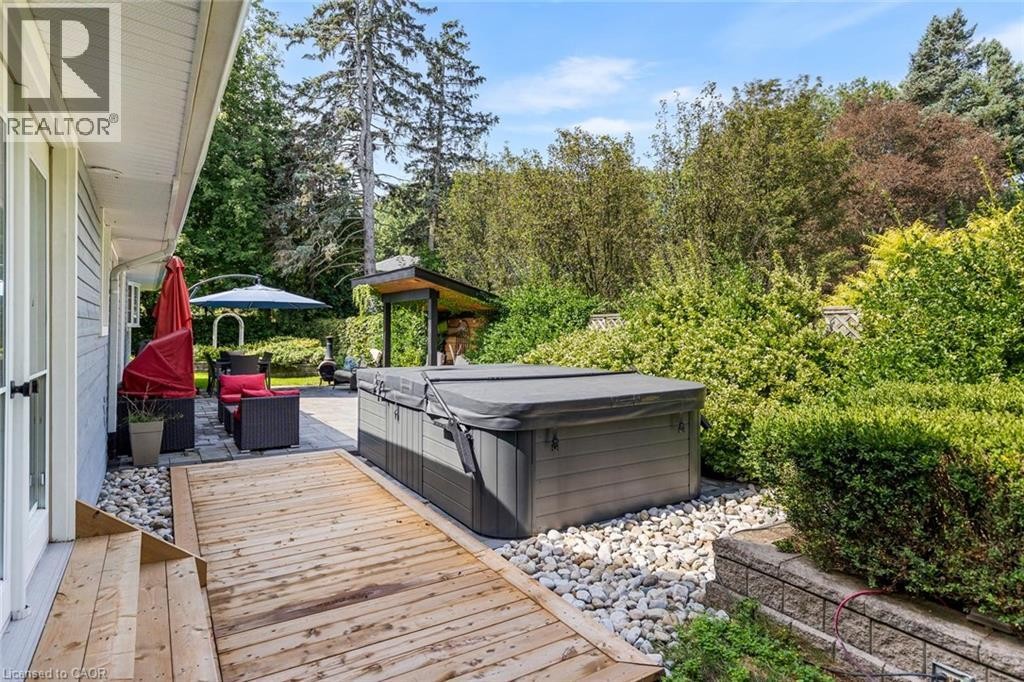Hardscaping featuring a wood deck, a stone patio, and a hot tub - 293 North Shore Boulevard E, Burlington, ON