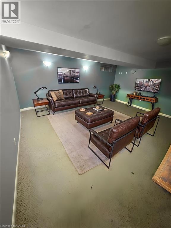 Finished basement recreation room featuring recessed lighting, neutral wall finishes, and polished concrete flooring throughout - 717 Activa Avenue, Kitchener, ON