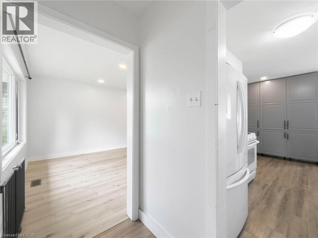 Recessed lighting, wood-finish flooring, white walls, double-pane window, and full-height built-in cabinetry - 220 Cairn Street, London, ON