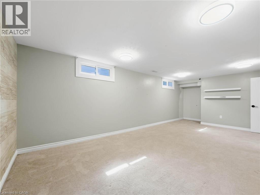 Finished room featuring neutral carpeting, light gray wall paint, and recessed windows - 220 Cairn Street, London, ON