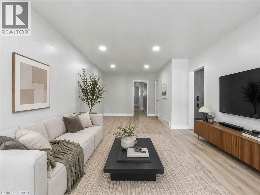 Recessed lighting illuminates the living area with light wood-finish flooring - 220 Cairn Street, London, ON
