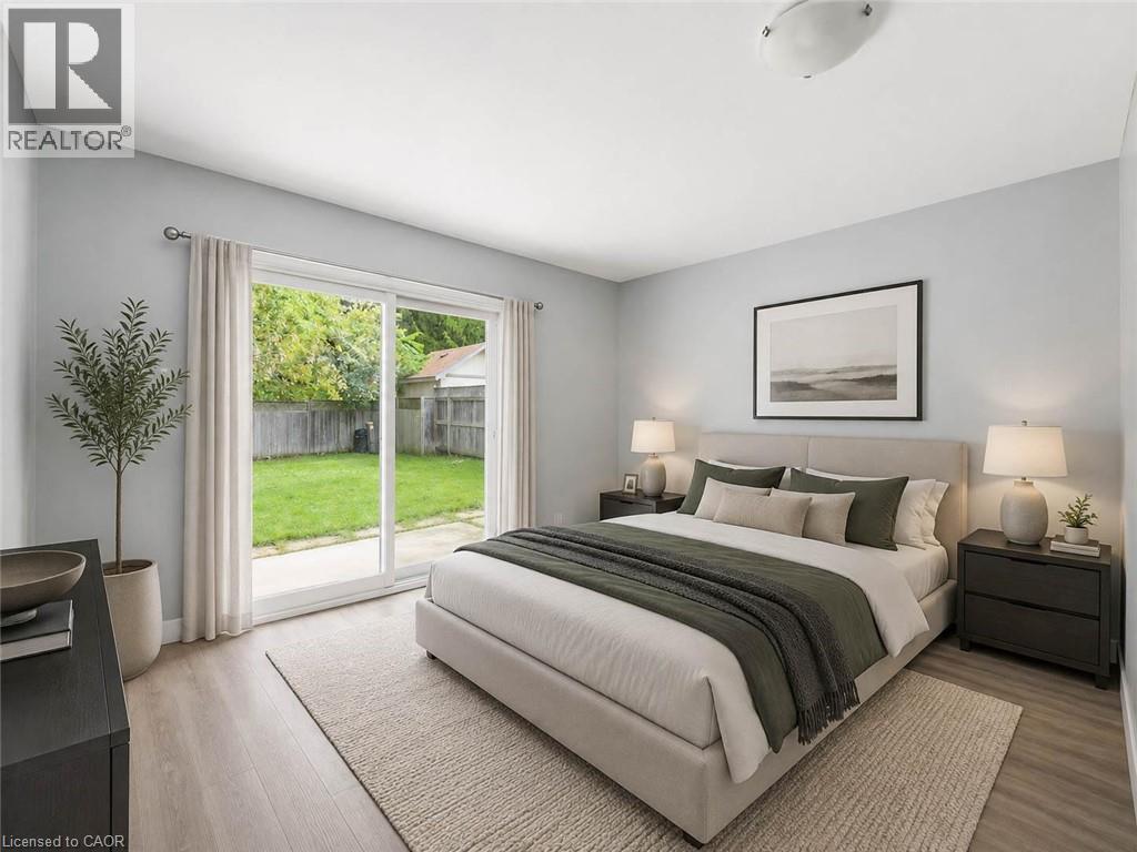 Wood-finish flooring, sliding glass door, recessed lighting, and a neutral color palette - 220 Cairn Street, London, ON