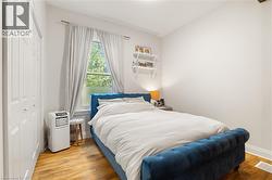 Wood-finish flooring with white walls and a white paneled closet - 