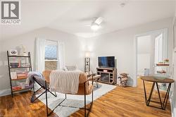 Vaulted ceiling with a ceiling fan, wood-finish flooring, and white walls - 