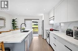 Modern kitchen featuring an extended island with a black gooseneck faucet and undermount sink - 