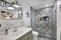 Bathroom featuring a walk-in shower with patterned tile, glass enclosure, and recessed shelf - 