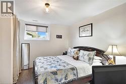 Bedroom featuring a window with roller shades, and a flush-mount ceiling light fixture - 