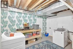 Second laundry room featuring a washer and dryer, and a built-in wooden shelving unit - 