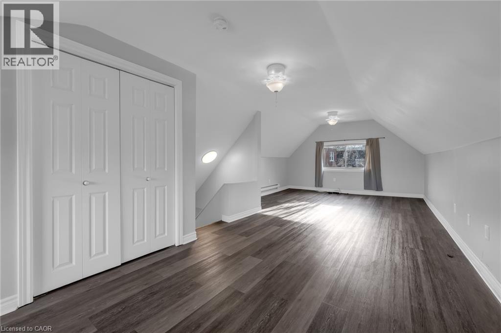Sloped ceiling architecture with recessed lighting, wood-finish flooring, and built-in closet storage - 9 Melrose Avenue S Unit# Upper, Hamilton, ON