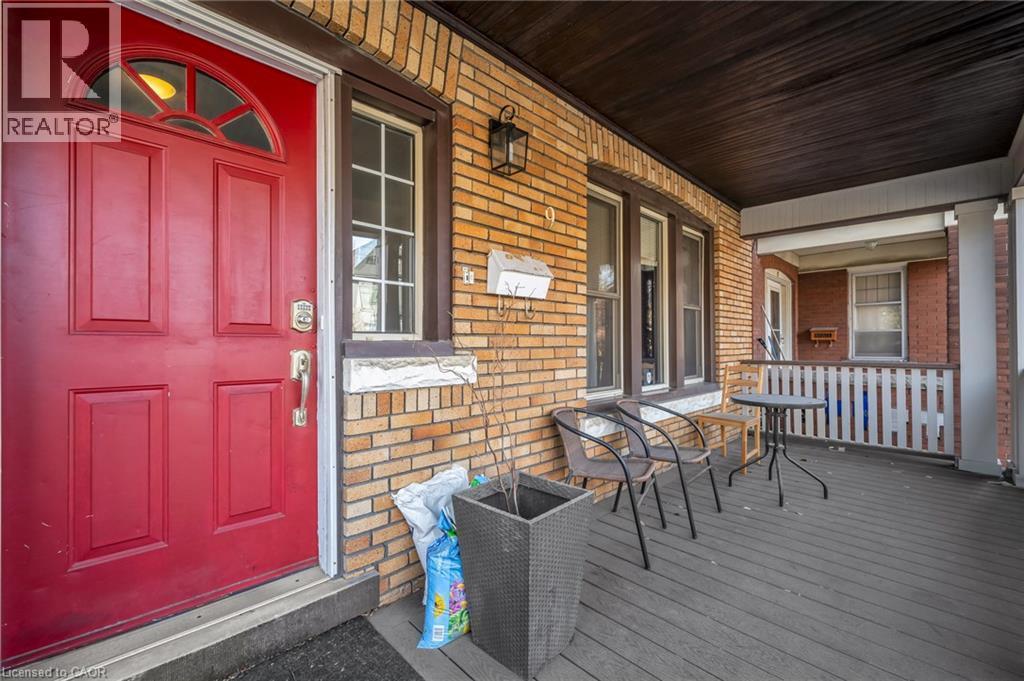 Brick exterior with a red paneled entry door featuring a transom window - 9 Melrose Avenue S Unit# Upper, Hamilton, ON