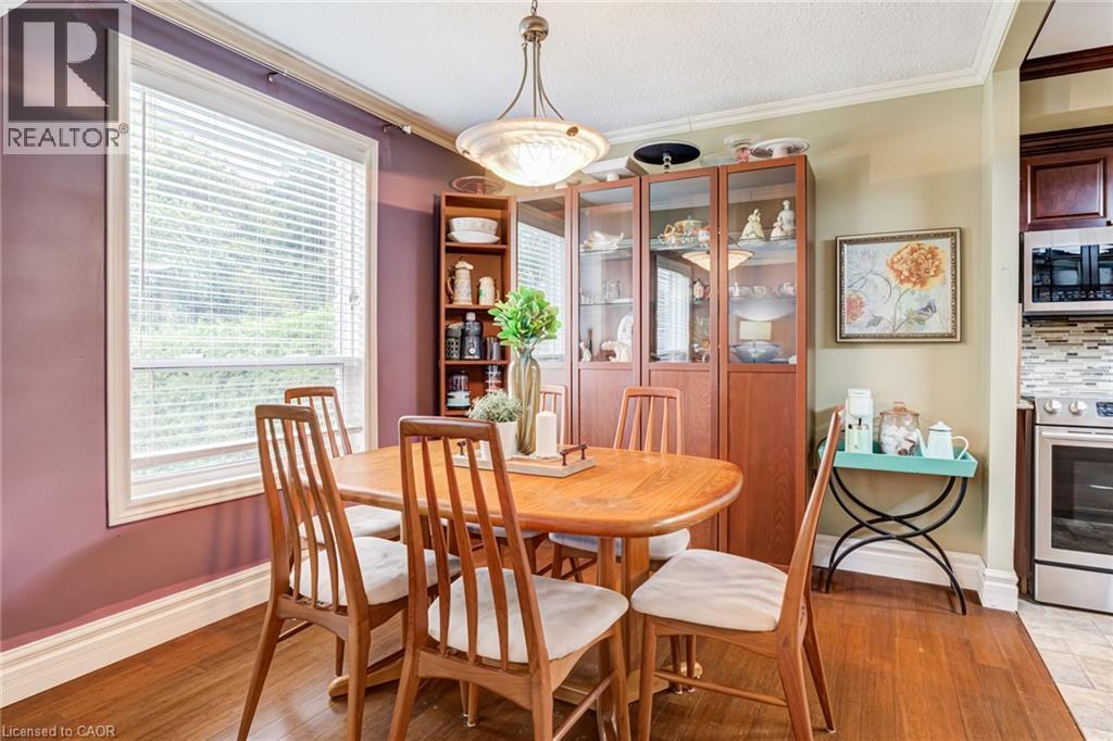 Wood-finish flooring, built-in display cabinetry, and crown molding - 106 Appleford Road, Hamilton, ON