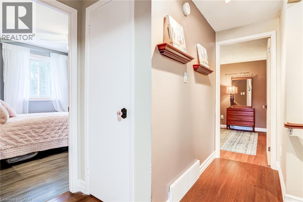 Hallway with wood-finish flooring and neutral wall tones - 106 Appleford Road, Hamilton, ON