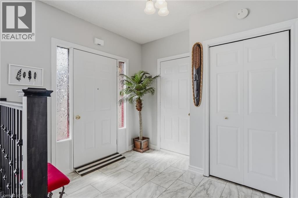 Entryway featuring a white paneled door with side lights, light-toned tile flooring, and a semi-flush mount ceiling light - 9 Country Club Road, Cayuga, ON
