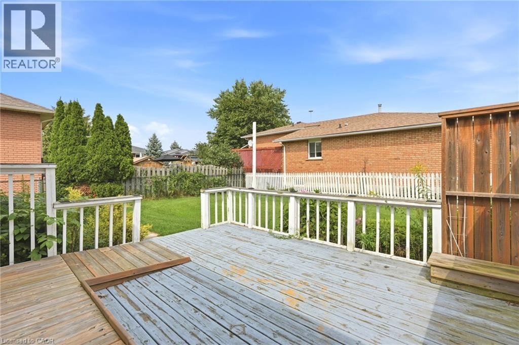 Expansive outdoor deck with wood flooring and white railing - 9 Country Club Road, Cayuga, ON