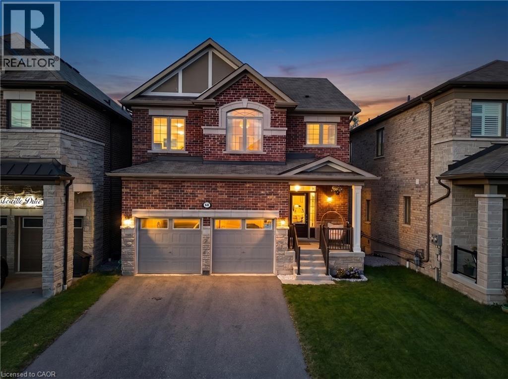 Brick and stone facade featuring a prominent gable, arched window, and covered front entry - 68 Barkerville Drive, Whitby, ON