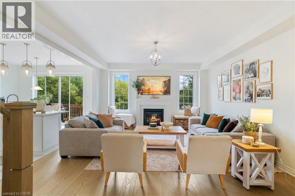 Open-concept living space featuring wood-finish flooring, a fireplace with a mantel, and recessed lighting - 68 Barkerville Drive, Whitby, ON