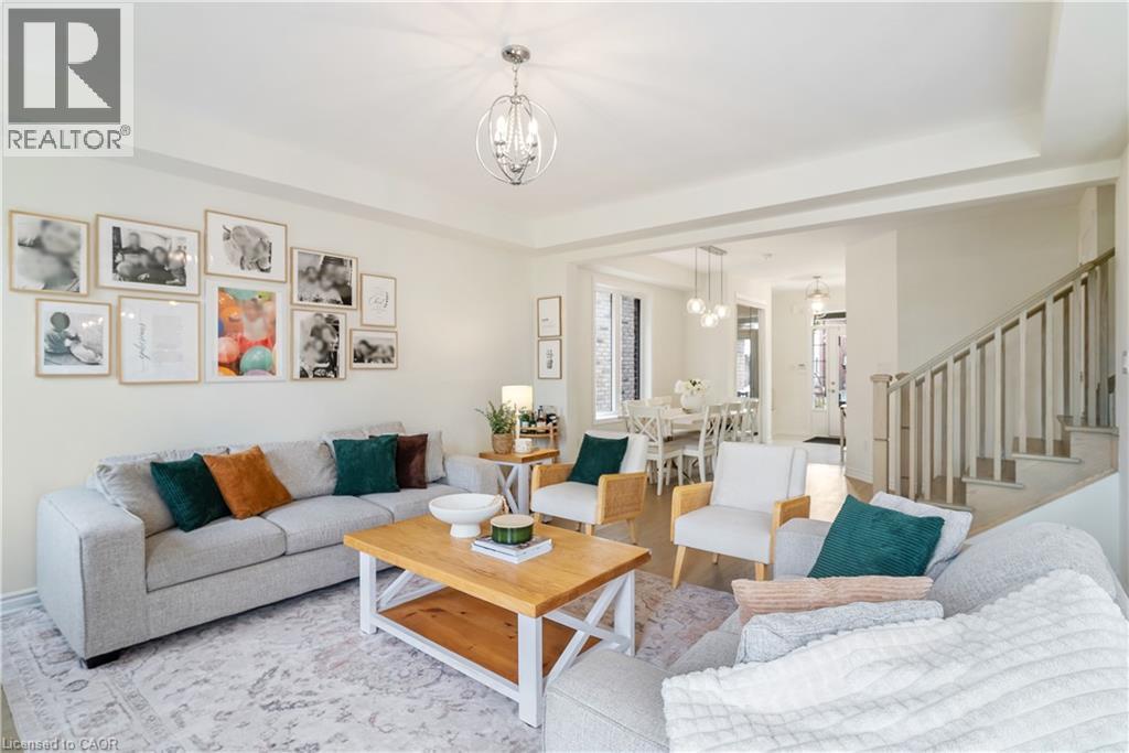 Recessed lighting throughout, contemporary chandelier, wood-finish flooring, staircase with painted balusters, and crown molding - 68 Barkerville Drive, Whitby, ON