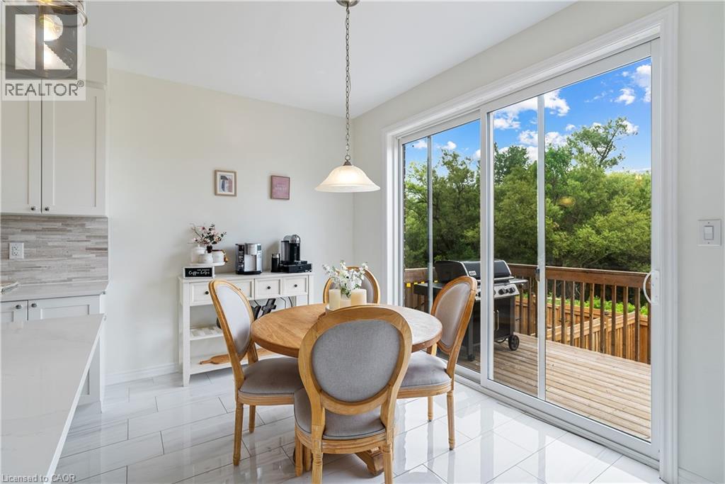 White shaker-style cabinetry, light-toned countertop, mosaic tile backsplash, and light-toned tile flooring - 68 Barkerville Drive, Whitby, ON