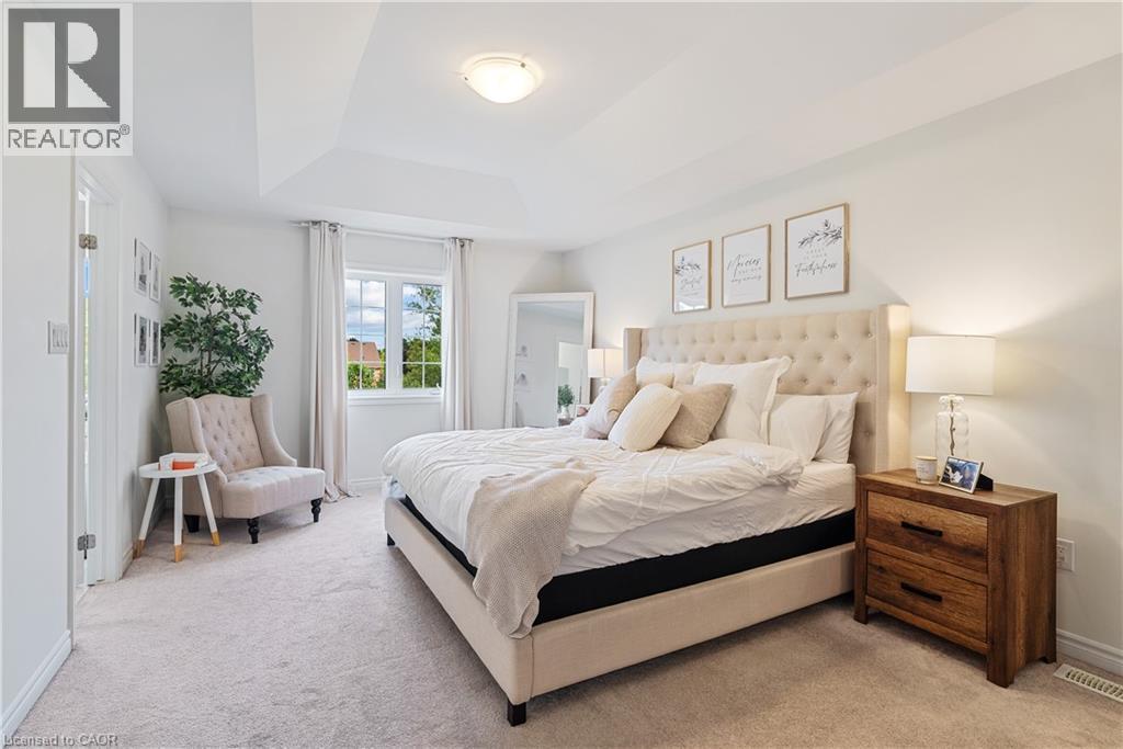 Tray ceiling with a flush mount light fixture, window with drapes, and neutral wall-to-wall carpeting - 68 Barkerville Drive, Whitby, ON
