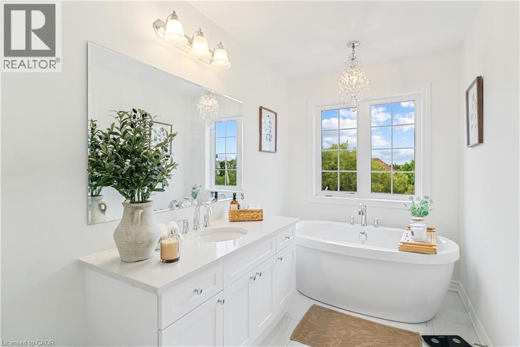 Dual basin vanity with chrome fixtures, a polished stone countertop, and built-in cabinetry - 68 Barkerville Drive, Whitby, ON
