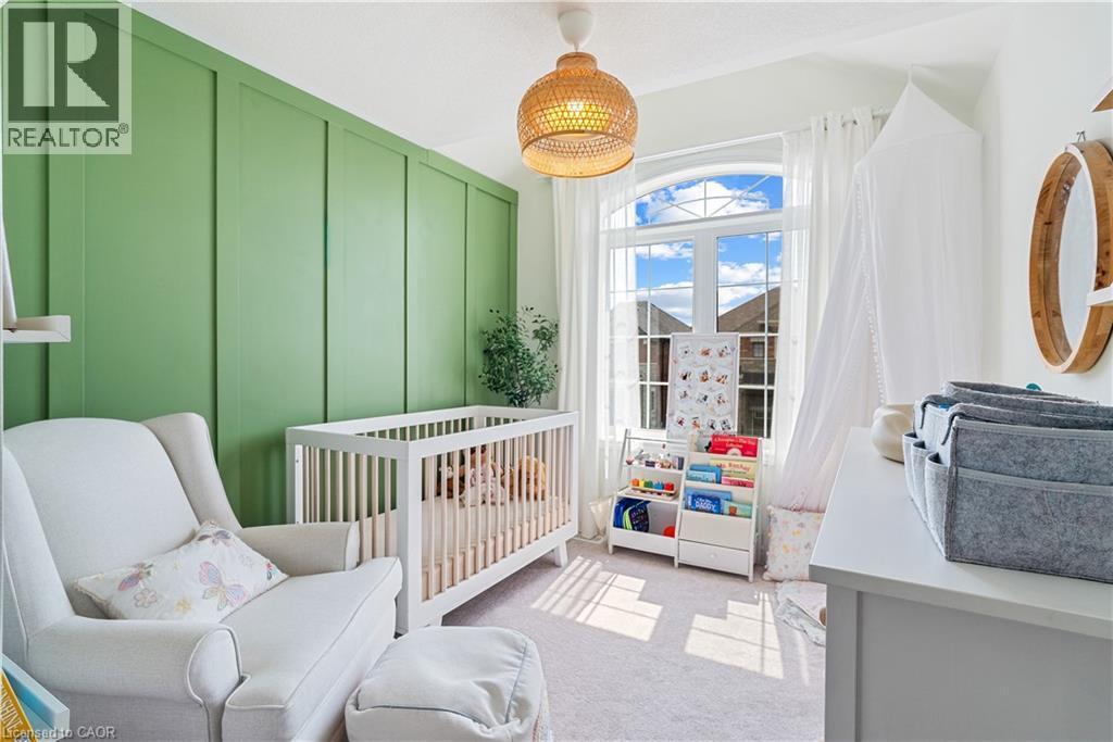 Board and batten accent wall, arched window with white trim, white window sheers, woven pendant light, and light-toned carpeting - 68 Barkerville Drive, Whitby, ON