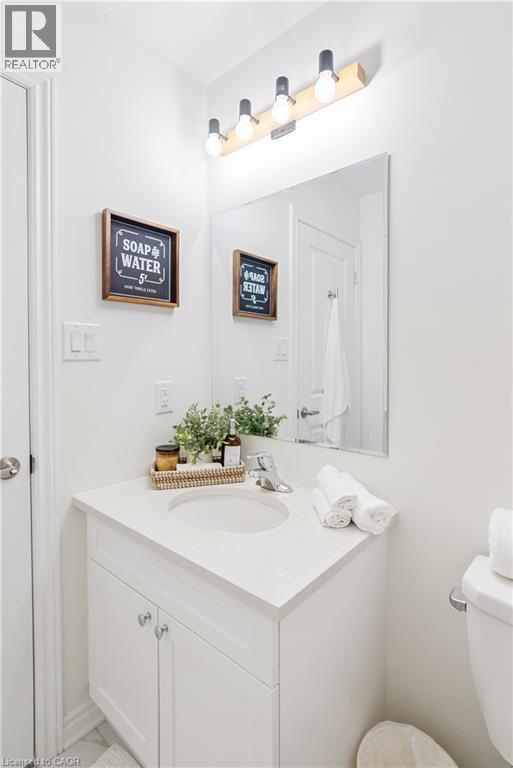 White vanity with an integrated sink, polished chrome faucet, and a rectangular mirror - 68 Barkerville Drive, Whitby, ON