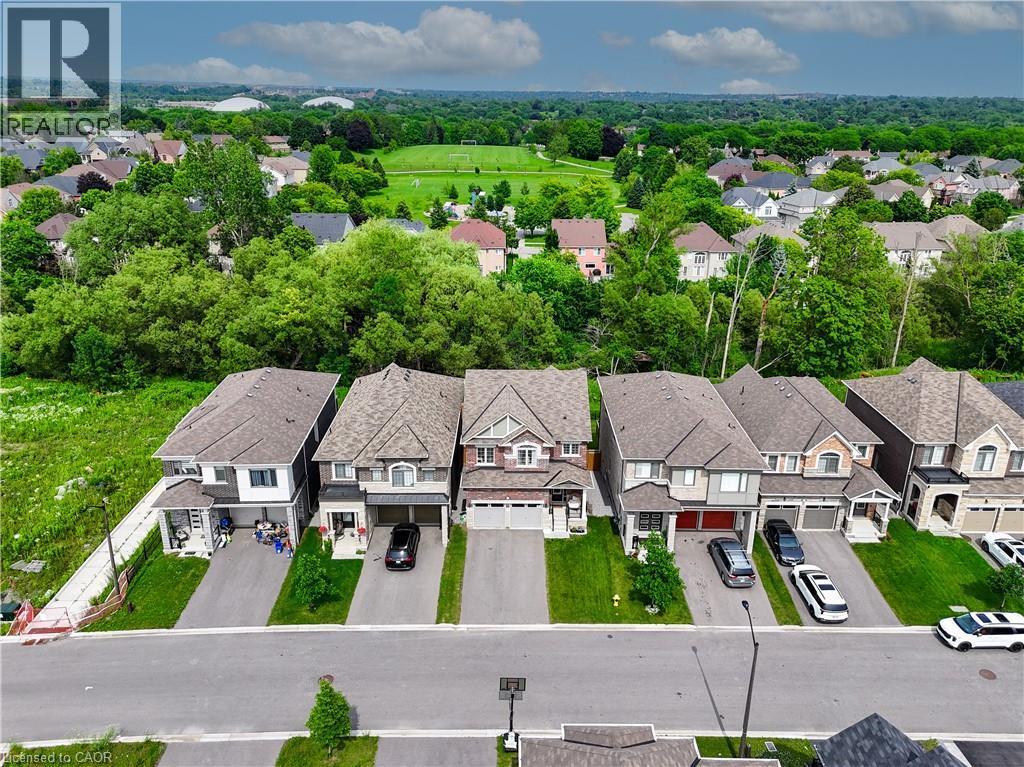Expansive residential neighborhood with mature trees and a distant recreational field - 68 Barkerville Drive, Whitby, ON